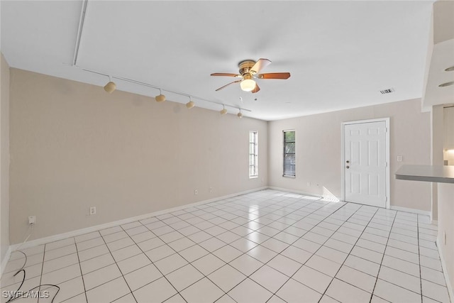 unfurnished room with light tile patterned floors, a ceiling fan, visible vents, and baseboards