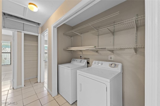 laundry room with light tile patterned floors, baseboards, and independent washer and dryer