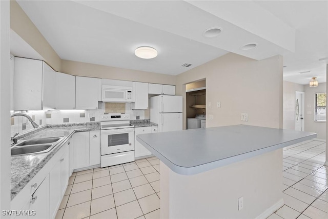 kitchen featuring white appliances, visible vents, light tile patterned flooring, a sink, and backsplash