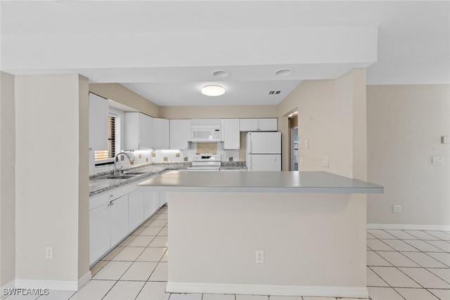 kitchen with a sink, white appliances, white cabinets, and light tile patterned floors