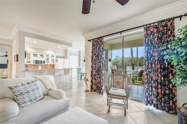 tiled living room with ceiling fan and crown molding