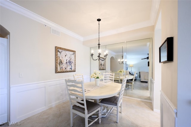 tiled dining room featuring ceiling fan with notable chandelier and crown molding