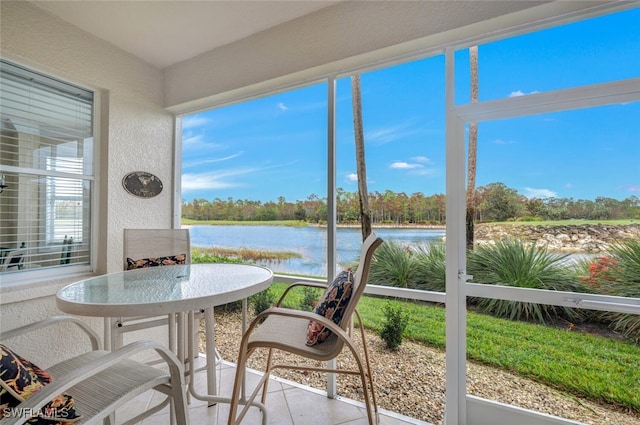 sunroom / solarium featuring a water view