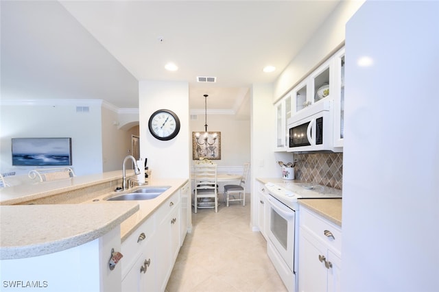 kitchen featuring sink, backsplash, decorative light fixtures, white appliances, and white cabinets