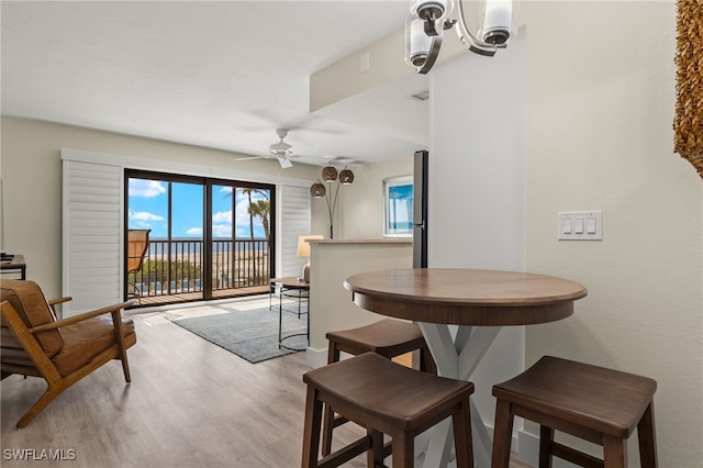 dining space with light hardwood / wood-style floors and ceiling fan