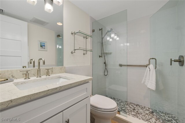 bathroom with vanity, toilet, and walk in shower