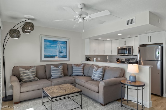 living room featuring ceiling fan and light wood-type flooring