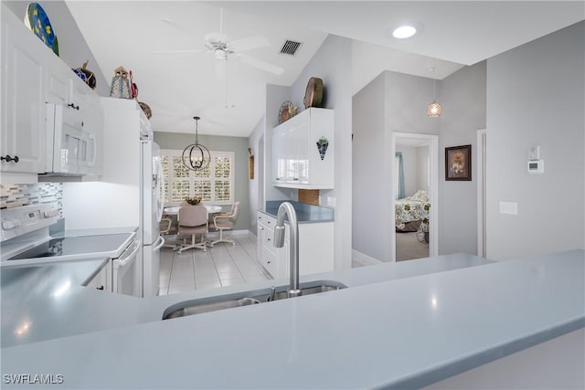 kitchen featuring white appliances, a sink, visible vents, white cabinets, and light countertops