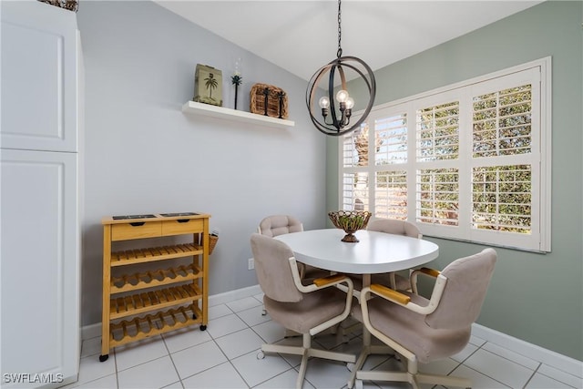 dining space with a chandelier, vaulted ceiling, baseboards, and light tile patterned floors