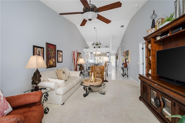 living area with ceiling fan with notable chandelier, visible vents, high vaulted ceiling, and light colored carpet