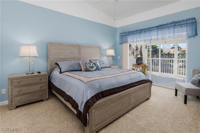 bedroom featuring access to outside, light carpet, lofted ceiling, and baseboards