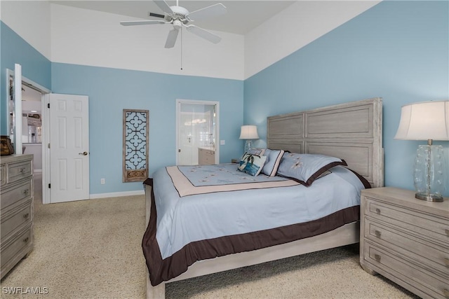 bedroom featuring a high ceiling, connected bathroom, a ceiling fan, and baseboards