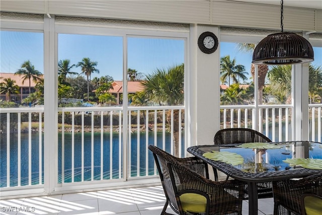 sunroom / solarium featuring a water view