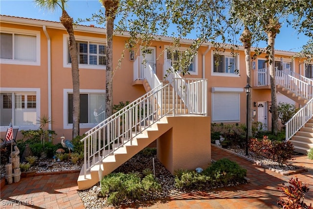 view of front of property with stairs and stucco siding