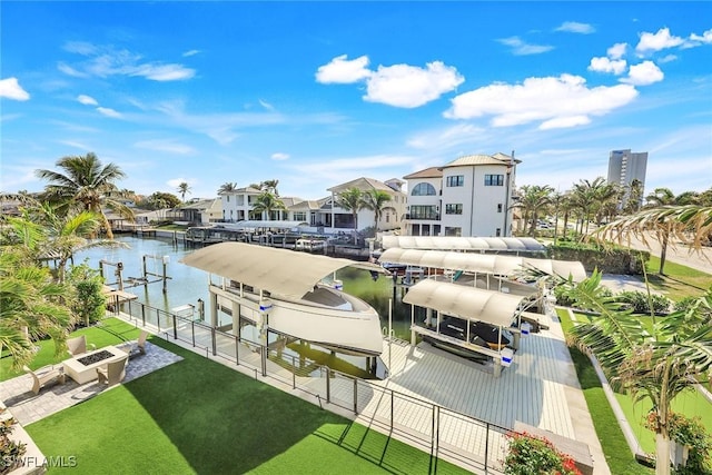 view of community with a boat dock, a water view, and a lawn