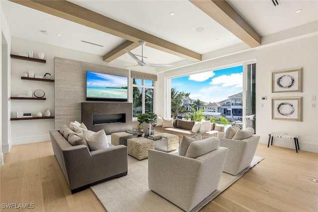 living room with beam ceiling, ceiling fan, and light wood-type flooring