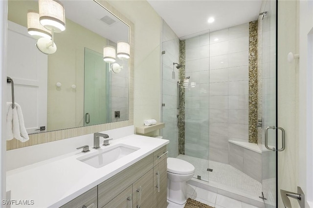 bathroom with vanity, toilet, and a shower with shower door