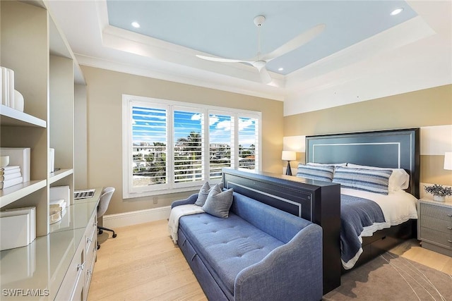 bedroom with a tray ceiling, ceiling fan, and light hardwood / wood-style floors