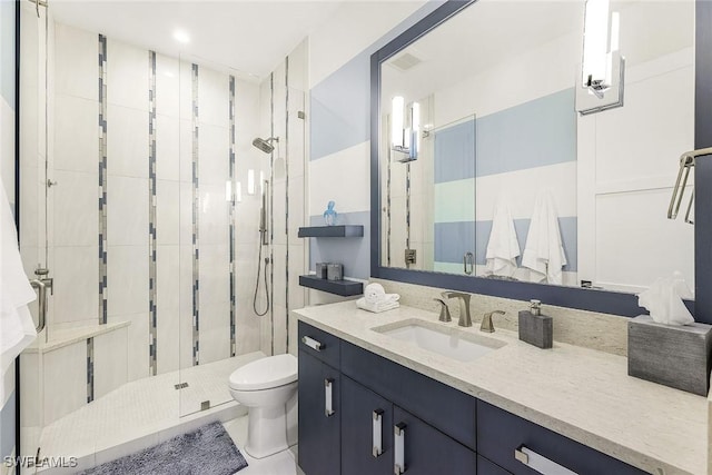 bathroom featuring tile patterned floors, vanity, toilet, and walk in shower