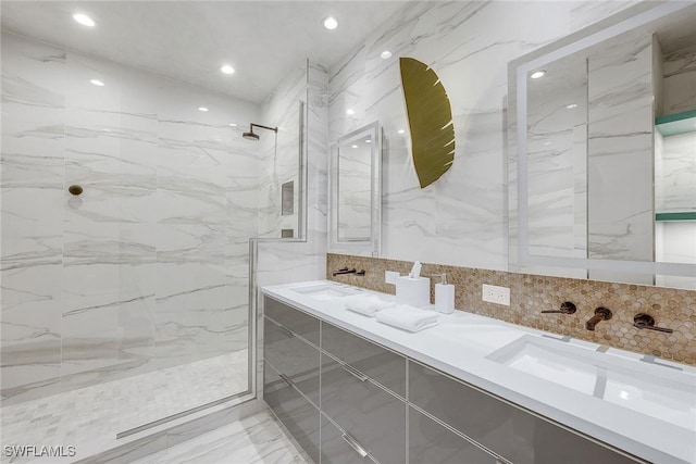 bathroom with a tile shower and vanity