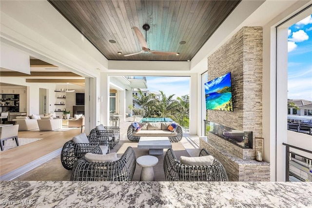 view of patio featuring an outdoor living space with a fireplace and ceiling fan