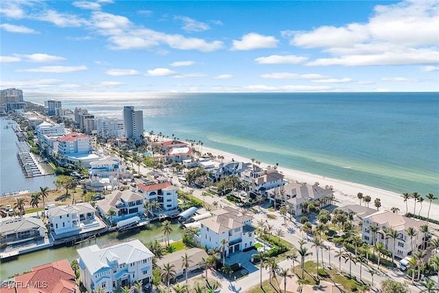 birds eye view of property with a water view and a beach view