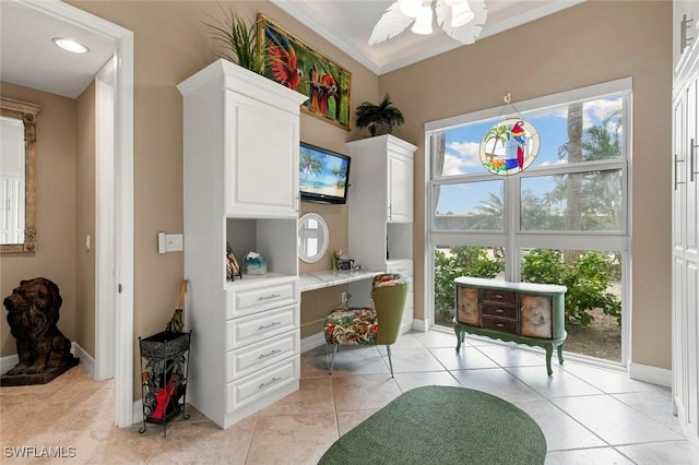 home office featuring light tile patterned flooring, a ceiling fan, baseboards, and ornamental molding