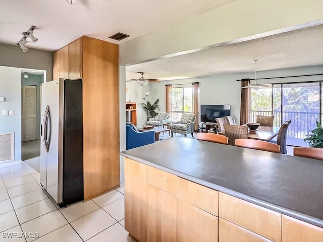 kitchen featuring light tile patterned floors, track lighting, ceiling fan, and stainless steel refrigerator with ice dispenser