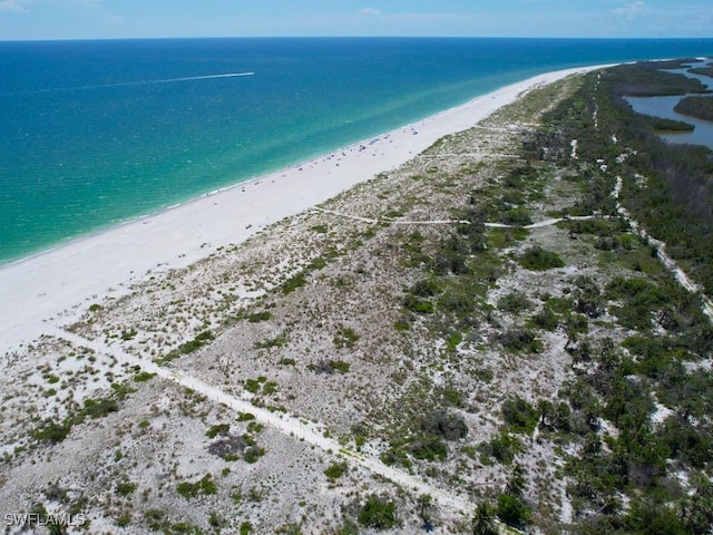 drone / aerial view featuring a water view and a beach view