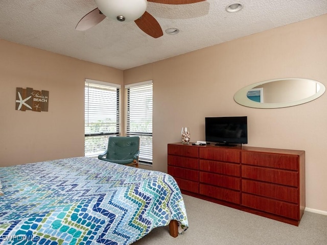 carpeted bedroom featuring a textured ceiling and ceiling fan