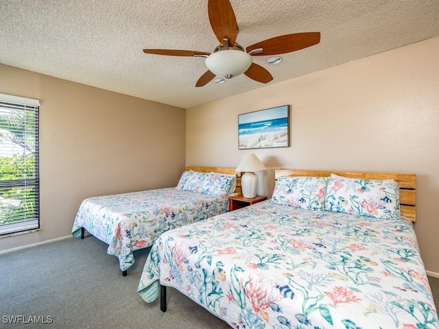 bedroom with ceiling fan, carpet flooring, and a textured ceiling