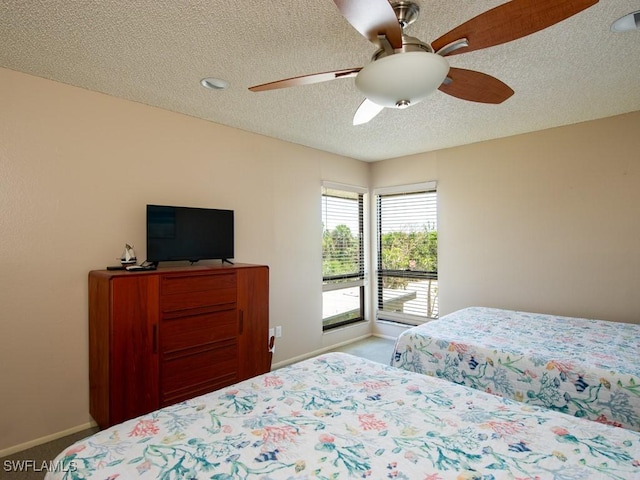 carpeted bedroom featuring a textured ceiling and ceiling fan