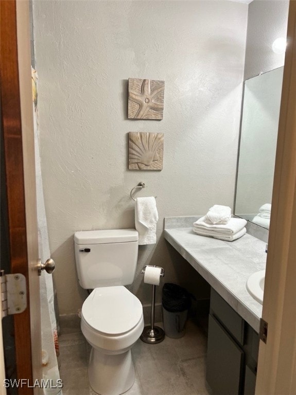 bathroom with tile patterned flooring, vanity, and toilet