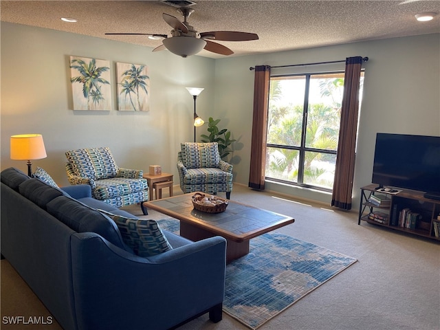 carpeted living room with ceiling fan and a textured ceiling