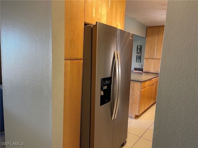 kitchen with stainless steel fridge and light tile patterned floors