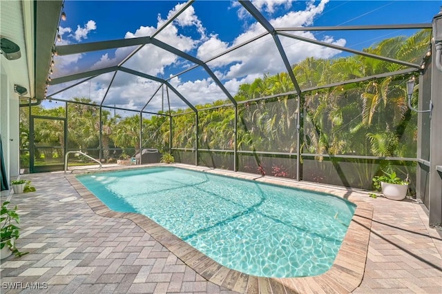 view of pool featuring a patio area and glass enclosure