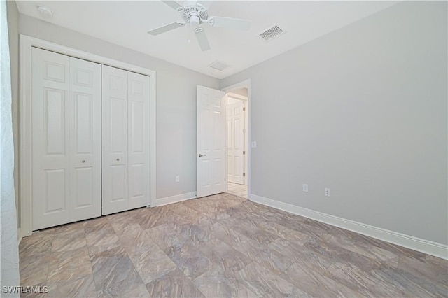 unfurnished bedroom featuring ceiling fan and a closet