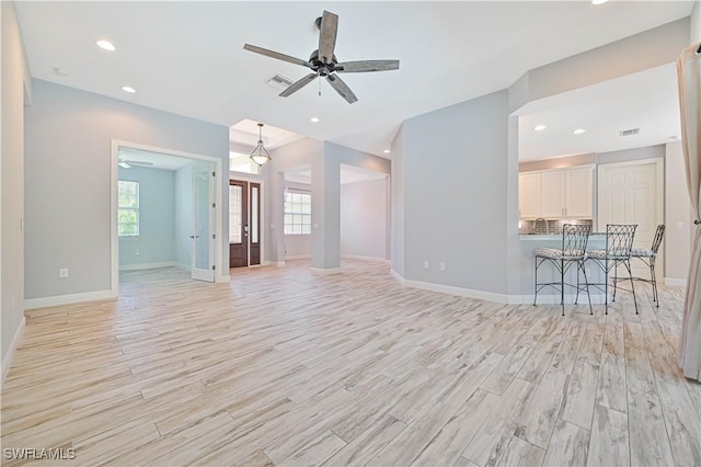 unfurnished living room with ceiling fan and light hardwood / wood-style flooring