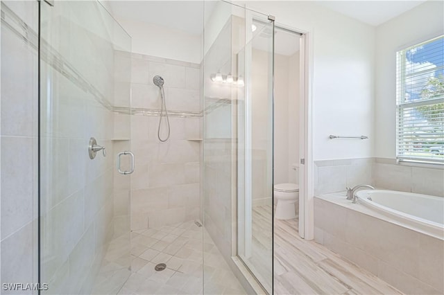 bathroom featuring toilet and shower with separate bathtub