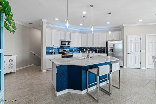 kitchen featuring pendant lighting, a center island with sink, sink, appliances with stainless steel finishes, and white cabinetry