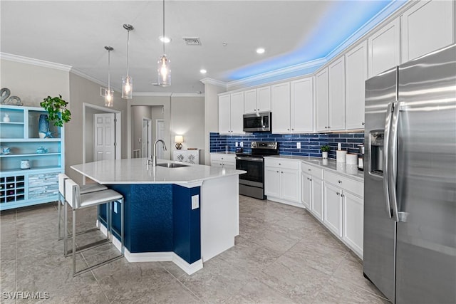 kitchen with white cabinets, sink, hanging light fixtures, an island with sink, and stainless steel appliances