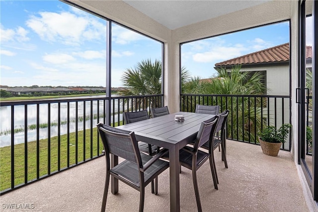 sunroom featuring a water view