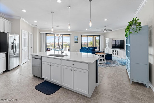 kitchen featuring a kitchen island with sink, white cabinets, sink, ceiling fan, and stainless steel appliances