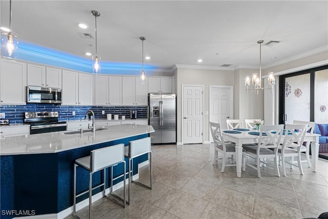 kitchen with stainless steel appliances, sink, an inviting chandelier, white cabinetry, and hanging light fixtures