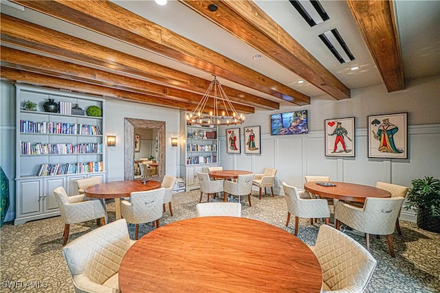 carpeted dining area with beam ceiling, built in features, and a notable chandelier