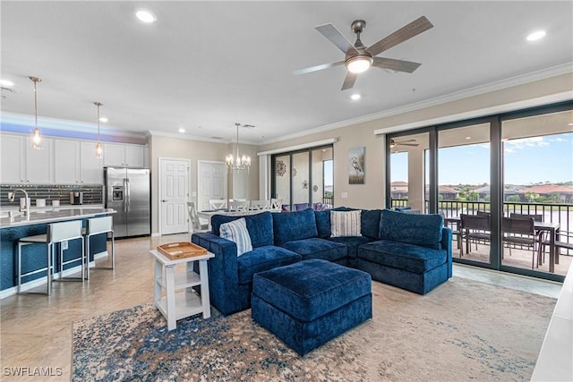 tiled living room featuring ceiling fan with notable chandelier, ornamental molding, and sink