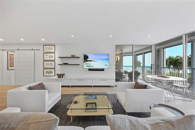 living room with hardwood / wood-style flooring, a barn door, and a healthy amount of sunlight