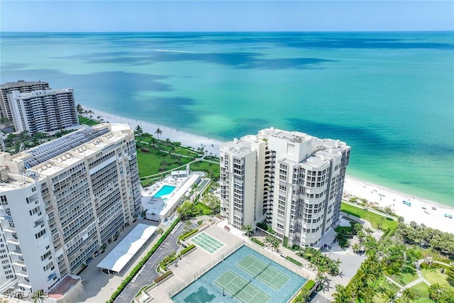 birds eye view of property with a water view and a beach view