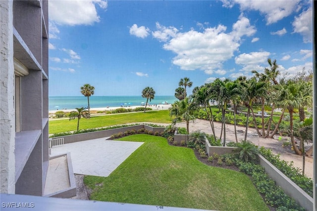 view of yard featuring a water view and a beach view