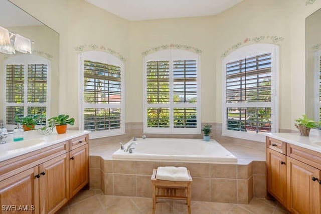 bathroom featuring vanity, tiled tub, and a wealth of natural light